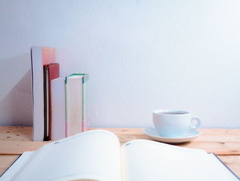 Close-up of coffee cup on table against wall