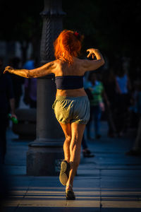 Full length rear view of woman standing against blurred background