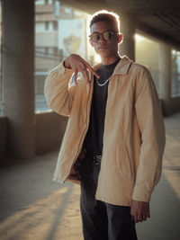 Portrait of young man standing against wall