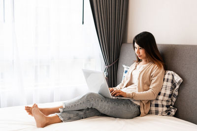 Young woman using digital tablet at home