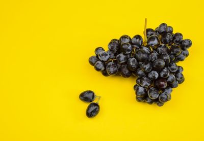 High angle view of blackberries against yellow background