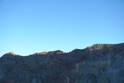 Scenic view of mountains against clear blue sky