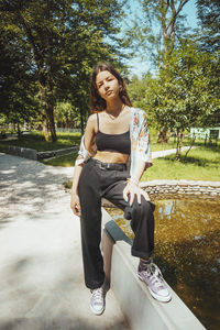 Portrait of young woman standing in park