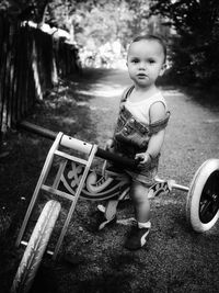 Portrait of cute girl sitting on toy scooter