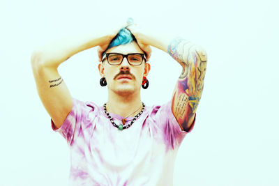 Portrait of young man standing against white background