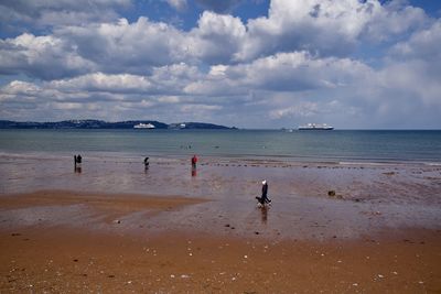 People on beach against sky