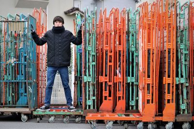 Full length of boy standing amidst push carts