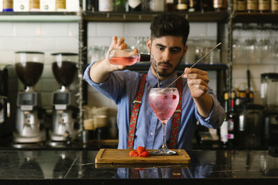 Bartender making drink on counter in bar