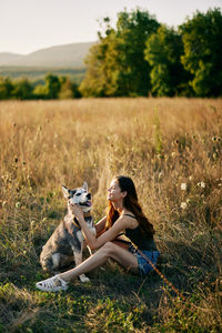 Side view of woman sitting on field