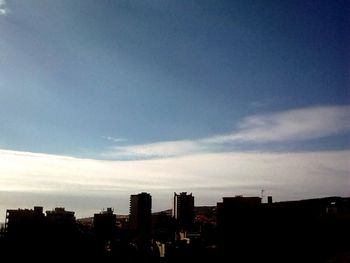 Silhouette cityscape against sky