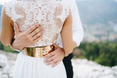 Midsection of woman holding umbrella while standing on land