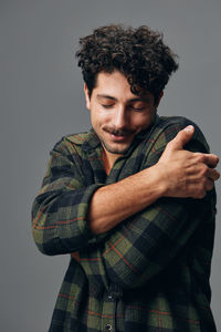 Portrait of young man standing against wall