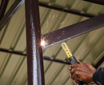 Close-up of person working on metal structure