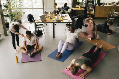 High angle view of multiracial colleagues exercising together at workplace