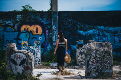 Woman standing against graffiti wall