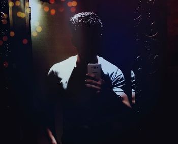 Man photographing through smart phone at night