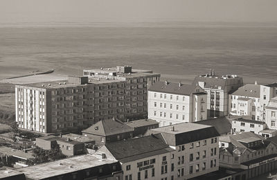 High angle view of buildings by sea against sky