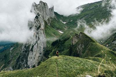 Rear view of man on mountain against sky