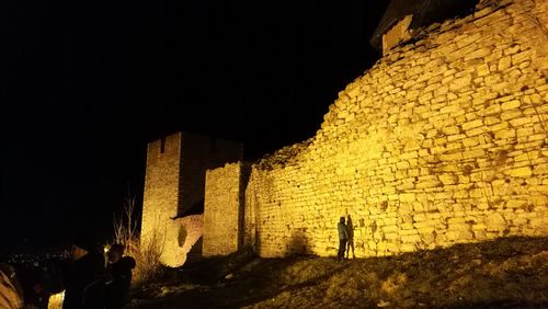 Panoramic view of illuminated building against sky at night