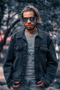 Portrait of young man wearing sunglasses standing outdoors