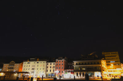 Low angle view of illuminated buildings against sky at night