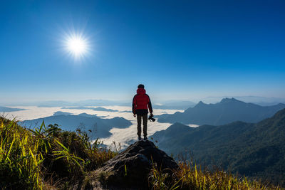 Man standing on mountain against sky