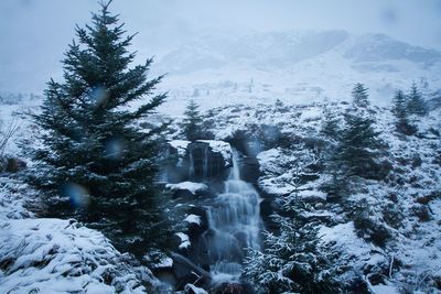 Scenic view of waterfall and mountain during winter