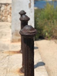 Close-up of rusty chain on wooden post