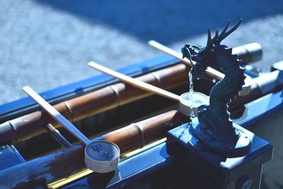 High angle view of wooden spoons by dragon drinking fountain at shinto shrine