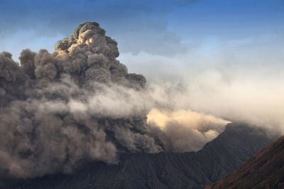 Smoke emitting from volcanic mountain against sky