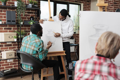 Rear view of man working at studio