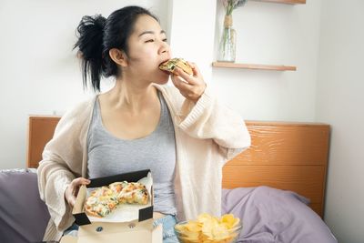 Young woman eating food at home