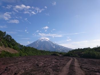 Road leading towards mountains against sky