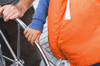 Midsection of people standing in boat