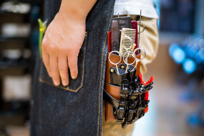 Midsection of barber with tools in salon