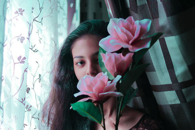 Portrait of beautiful woman by pink flowering plant