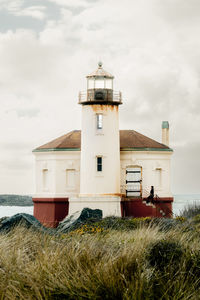 Lighthouse by sea against sky