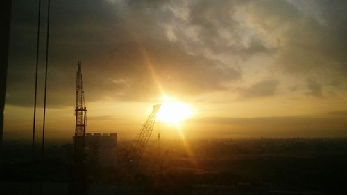 Silhouette of city against sky during sunset