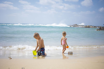 Little kids playing with sand on the sea beach. summertime fun. vacation vibe. family lifestyle 