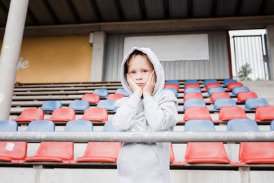 Boy looking out at a track looking nervous in sports clothes