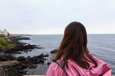 Rear view of woman looking at sea against sky