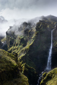 Scenic view of waterfall against sky