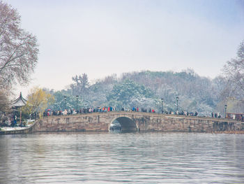 Arch bridge over river against sky