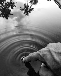 Midsection of person holding cigarette in water