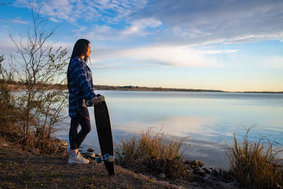 Woman looking at lake against sky