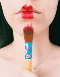 Close-up of woman with pink hair against black background