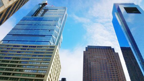 Low angle view of modern buildings against blue sky