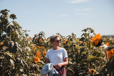 Full length of young woman standing against sky