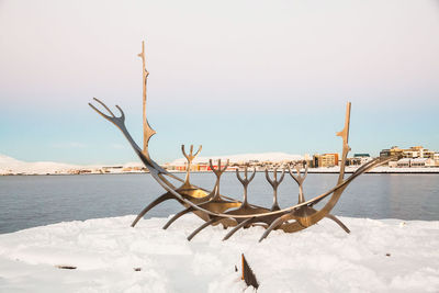 Snow on shore against clear sky