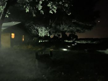 Illuminated buildings seen through wet window at night